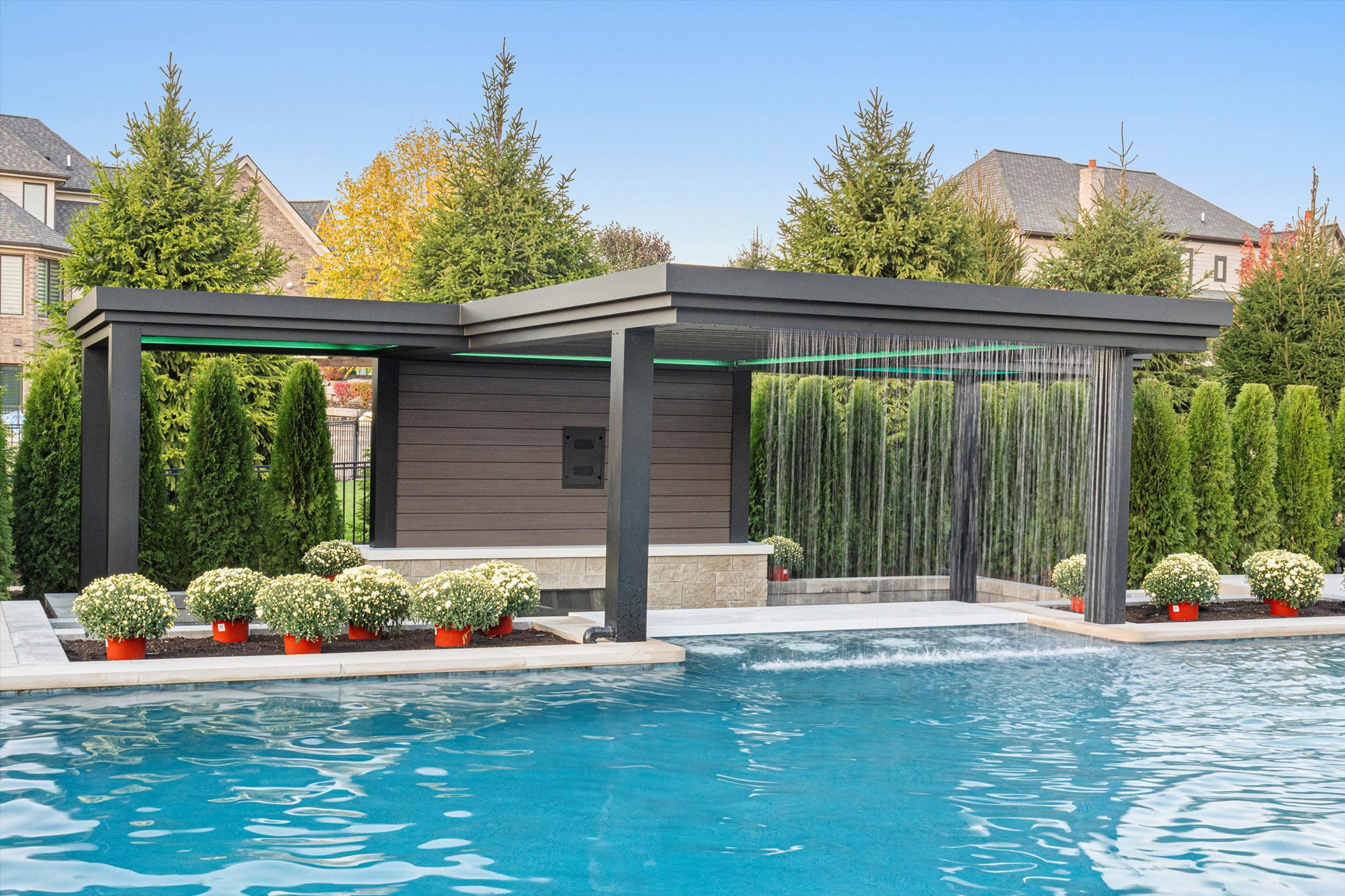 Forever Pergola adjacent pool with connecting waterfall